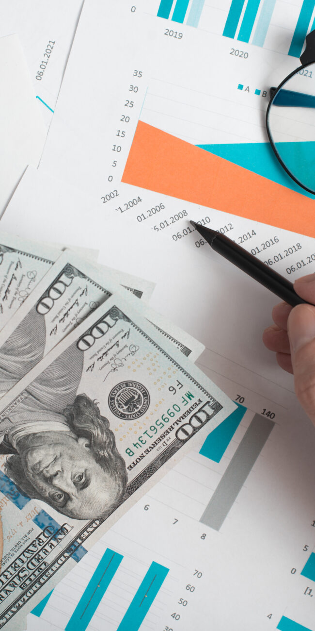 Pessoa fazendo conta de controle e fluxo de caia em cima da mesa